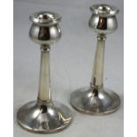 A silver pair of candlesticks, Birmingham 1928, with tulip form sconces to a tapering column with