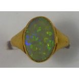 An 18ct gold opal dress ring, collet set with an oval stone, size G.