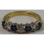 An 18ct gold sapphire and diamond seven stone ring, claw set with alternate brilliant cut stones,