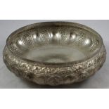 An Indian white metal bowl, unmarked, of lobed design with floral embossed and chased panels, raised
