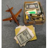 A box of assorted model locomotive parts and paperwork together with a model jet airliner