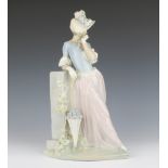 A Lladro figure of a standing lady with parasol beside a pedestal 38cm h The parasol is loose and