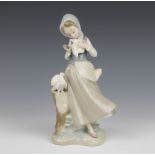 A Lladro figure of a standing girl with dove, the base impressed G-20 N43, 24cm h