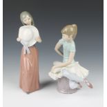 A Lladro figure of a ballerina sitting on a pouffe 20cm, a do. of a young lady holding a hat 25cm