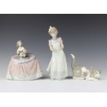 A Lladro figure of a cat crouching 12cm, a do. figure of a girl holding a puppy 15cm another of a