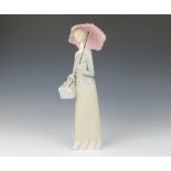 A Lladro figure of a lady standing, holding a parcel and a parasol 36cm A thumb and finger are