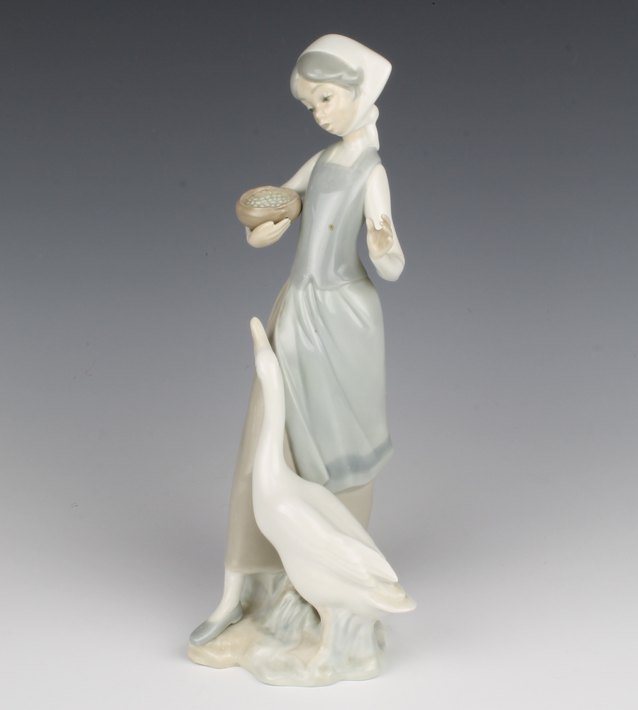 A Lladro figure of a girl with goose and bowl of food 25cm