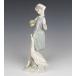 A Lladro figure of a girl with goose and bowl of food 25cm