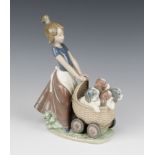 A Lladro figure of a girl pushing a pram containing puppies 5364, 23cm