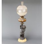 A Victorian faceted glass oil lamp reservoir raised on a spelter and marble base in the form of a