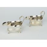 A pair of silver sauce boats with S scroll handles, shell knees and pad feet London 1937, 184 grams