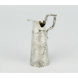 A Continental miniature repousse silver ewer decorated with cavorting cherubs 7cm