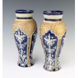 A pair of Doulton Lambeth oviform vases with stylised scrolls and flowers 27.5cm