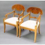 A pair of 19th Century Biedermeier bar back carver chairs with upholstered seats, raised on sabre