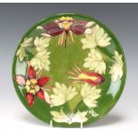 A Moorcroft green ground columbine pattern plate, circa 1980 with impressed and printed signature