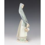 A Lladro figure of a lady holding a basket 32cm