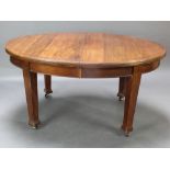 An Edwardian Art Nouveau mahogany oval extending dining table with 2 extra leaves raised on square