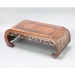 A Chinese rectangular carved padauk coffee table with pierced and carved apron raised on scroll