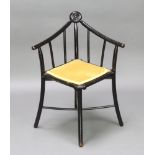 An Aesthetic Movement ebonised stick and rail back corner chair with X framed stretcher