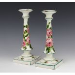 A pair of Wemyss tapered candlesticks on square bases decorated with roses, painted and impressed