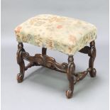 A Jacobean style mahogany framed rectangular stool with upholstered seat and wavy apron, raised on