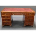 A mahogany kneehole desk with red inset leather writing surface above 1 long and 6 short drawers