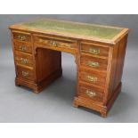 An Edwardian walnut kneehole desk with green inset writing surface above 1 long and 8 short