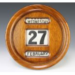 An Edwardian perpetual calendar contained in a circular oak case 32cm diam.
