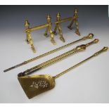 A pair of Art Nouveau reeded brass fire dogs together with a matching pair of tongs, shovel and an