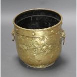 A cylindrical embossed brass twin handled jardiniere/coal bin with lion mask handles 37cm h x 36cm