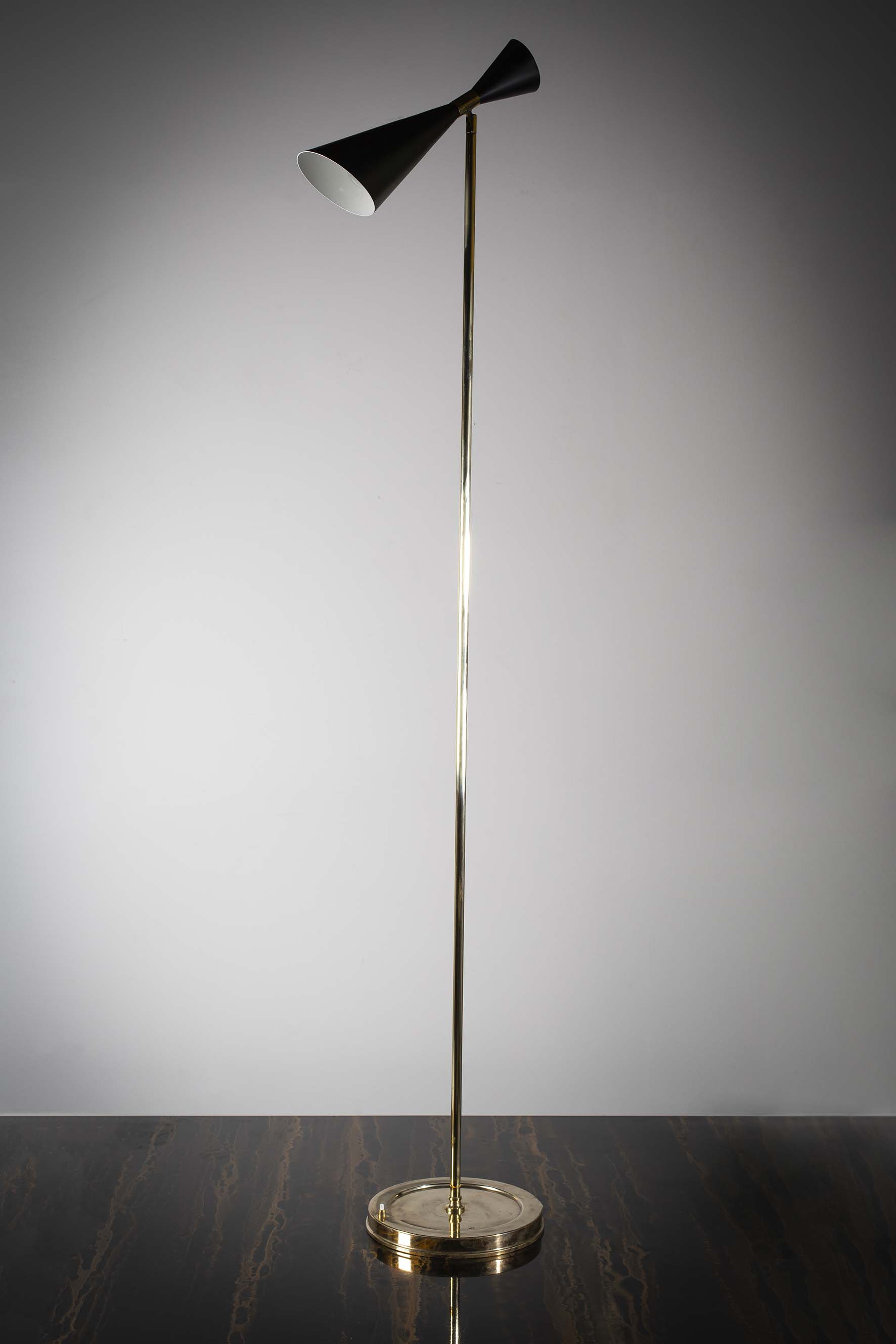 A TALL UPRIGHT FLOOR LIGHT, ITALIAN, 1960s, the adjustable tapering shade on a tubular brass