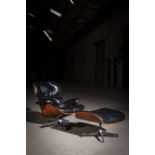 A 670/671 LOUNGE CHAIR AND OTTOMAN BY CHARLES & RAY EAMES, with black leather upholstery and