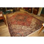 AN EARLY 20TH CENTURY CAUCASIAN CARPET, red ground with central floral medallion,