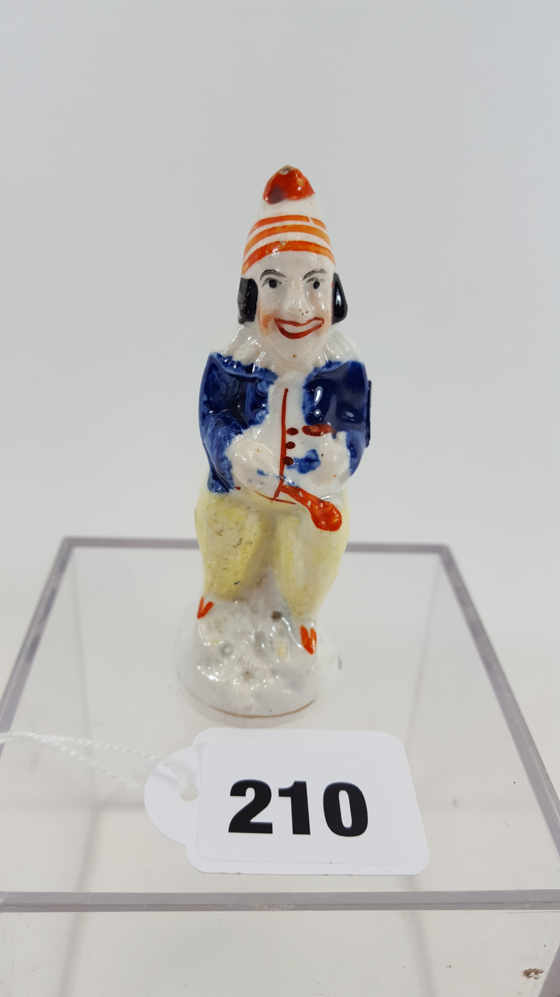A 19TH CENTURY MOULDED STAFFORDSHIRE POTTERY CANDLE SNUFFER/FIGURE in the form of Mr Punch,