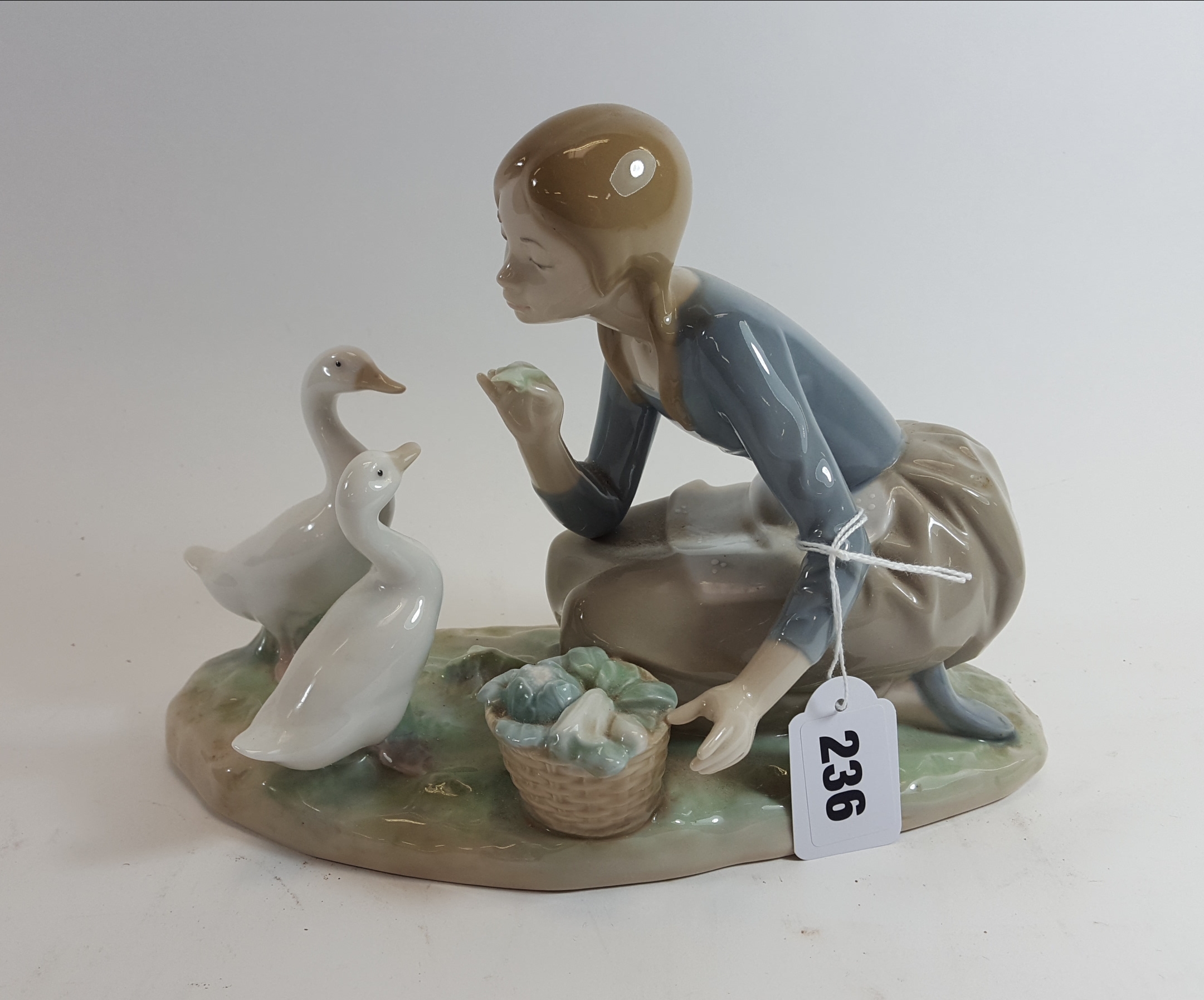 A 20TH CENTURY LLADRO PORCELAIN GROUP of a kneeling girl with two white geese, on an ovoid base,