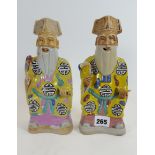 TWO CHINESE PORCELAIN FIGURES of seated dignitaries decorated in polychrome enamels,