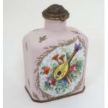 A limoges canister on pink ground highlighted with gilt with musical instruments on the front