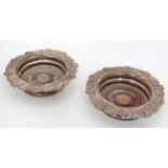 A pair of silver plate bottle coasters with turned wooden bases Each 8" diameter overall