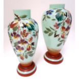 Two glass vases, the pale green ground with hand painted floral decoration.