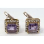 A pair of silver gilt earrings set with amethysts bordered by white stones.