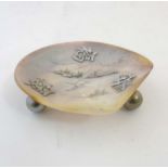 A Japanese mother of pearl dish with white metal script and engraved image within.