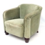 A Continental Art Deco green upholstered armchair on stained walnut shaped feet.