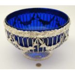A blue glass punch bowl with silver plated pedestal stand with scallop shell and fruiting vine