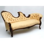 A Victorian walnut button back Chaise Longue with serpentine shaped back and intricately carved