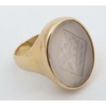 A yellow metal gold signet ring set with family crest intaglio chalcedony seal to top.