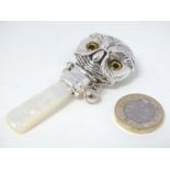 A silver novelty decorative rattle with mother of pearl handle / teether and owl head decoration 3"