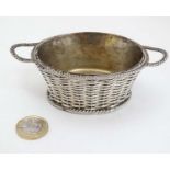 A silver plate table salt formed as a basket with ovoid liner.