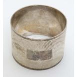 A silver napkin ring with engine turned decoration.