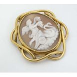 A late 19thC/ early 20thC shell carved cameo brooch depicting classical scene to centre in a gilt