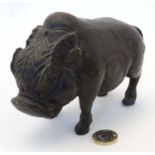 A Chinese hollow cast bronze figure of a boar pig with relief decoration.